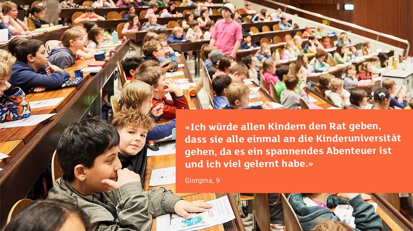 Ein voller Vorlesungssaal, indem Kinder sitzen und gespannt zuhören.